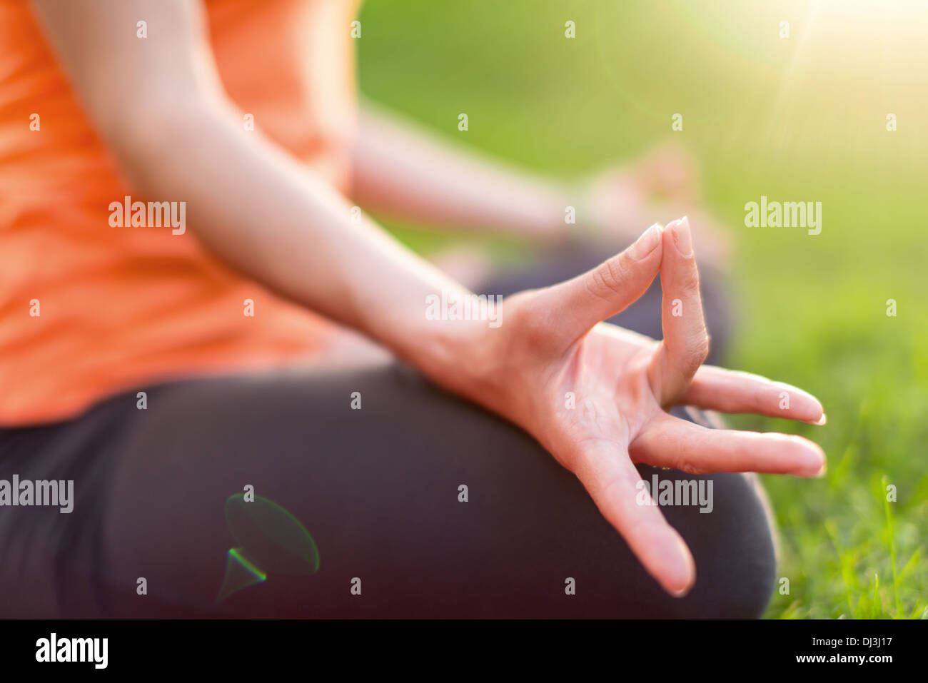 Hand-Detail von einem Mädchen Meditation und unter Yoga stellt bei Sonnenuntergang unter Bäumen Stockfoto