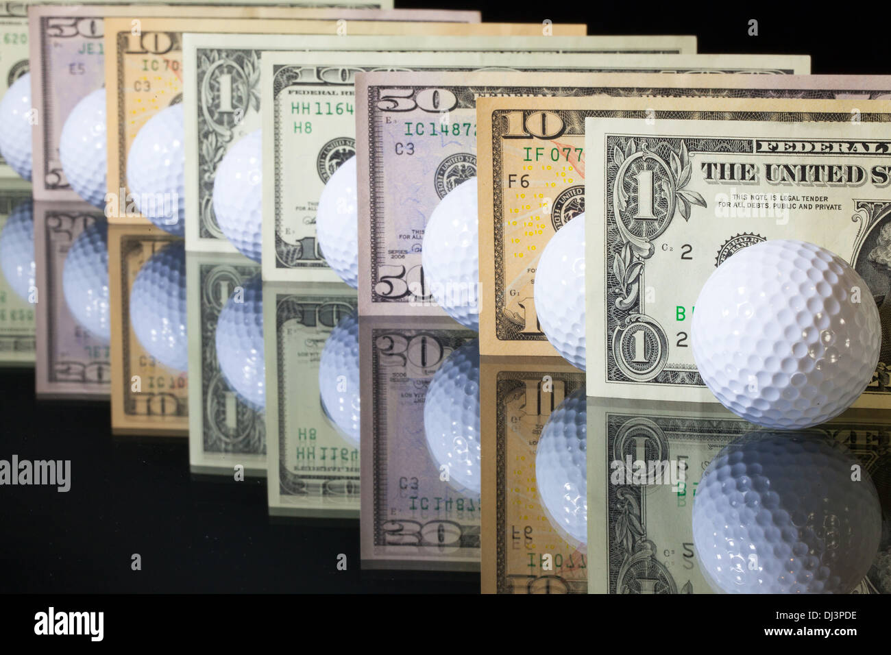 Weiße Golfbälle und US-Dollar-Banknoten Stockfoto