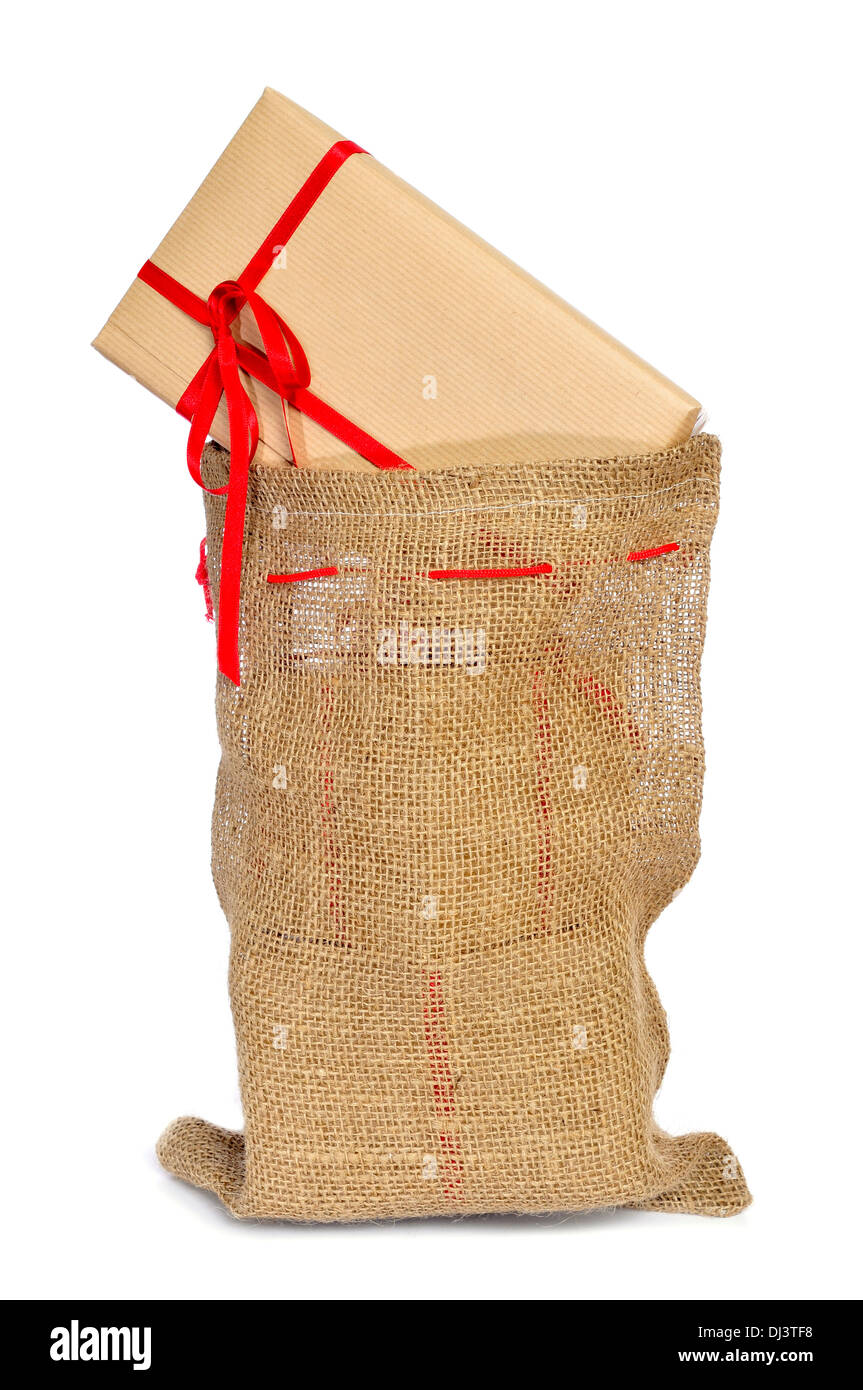 ein Haufen von Geschenken mit einem roten Band in ein Weihnachts-Strumpf auf weißem Hintergrund Stockfoto