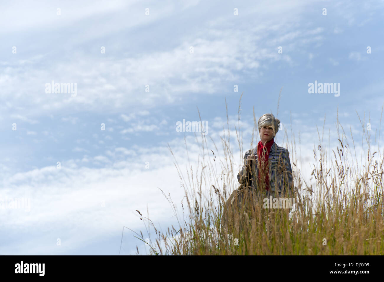 Frau in hohe Gräser auf einem Hügel Stockfoto