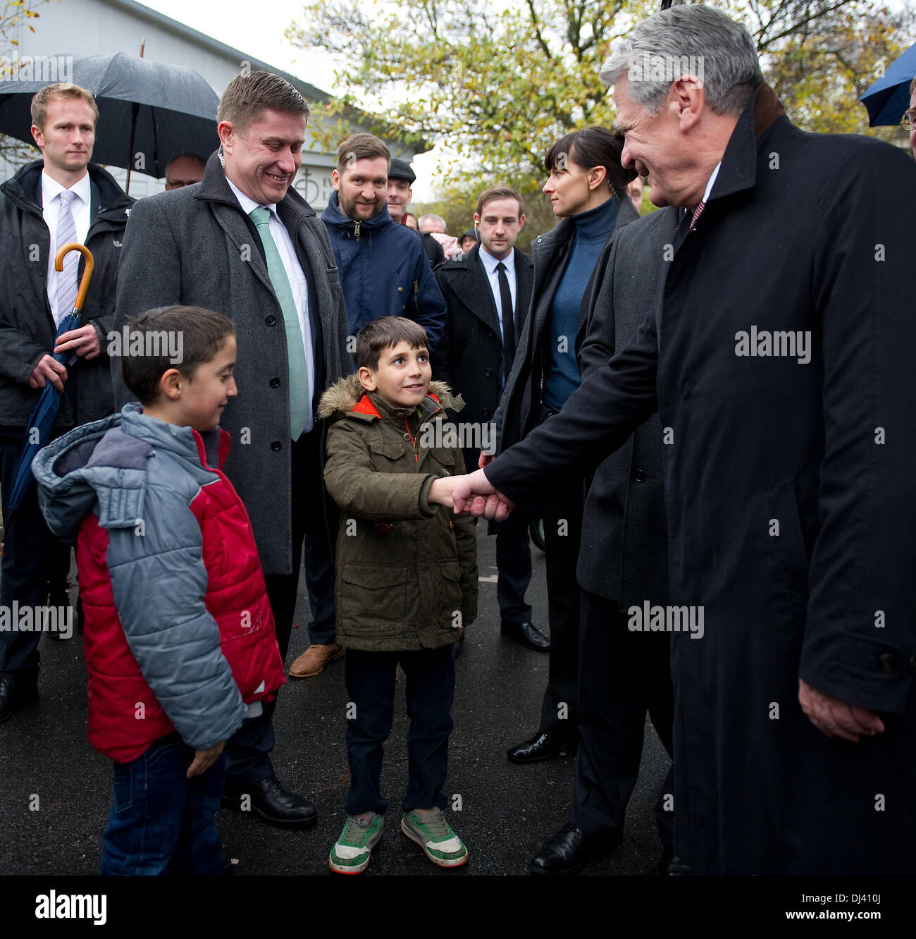 Der deutsche Bundespräsident Joachim Gauck schüttelt Hand mit einem syrischen Flüchtlingskind in der Flüchtlinge und Einwanderer transit Lager Friedland, Deutschland, 21. November 2013. Bundespräsident Joachim Gauck besucht die Grenze Durchgangslager Friedland um sich über die Situation der syrischen Flüchtlinge, die dort leben. Foto: SWEN PFOERTNER/dpa Stockfoto