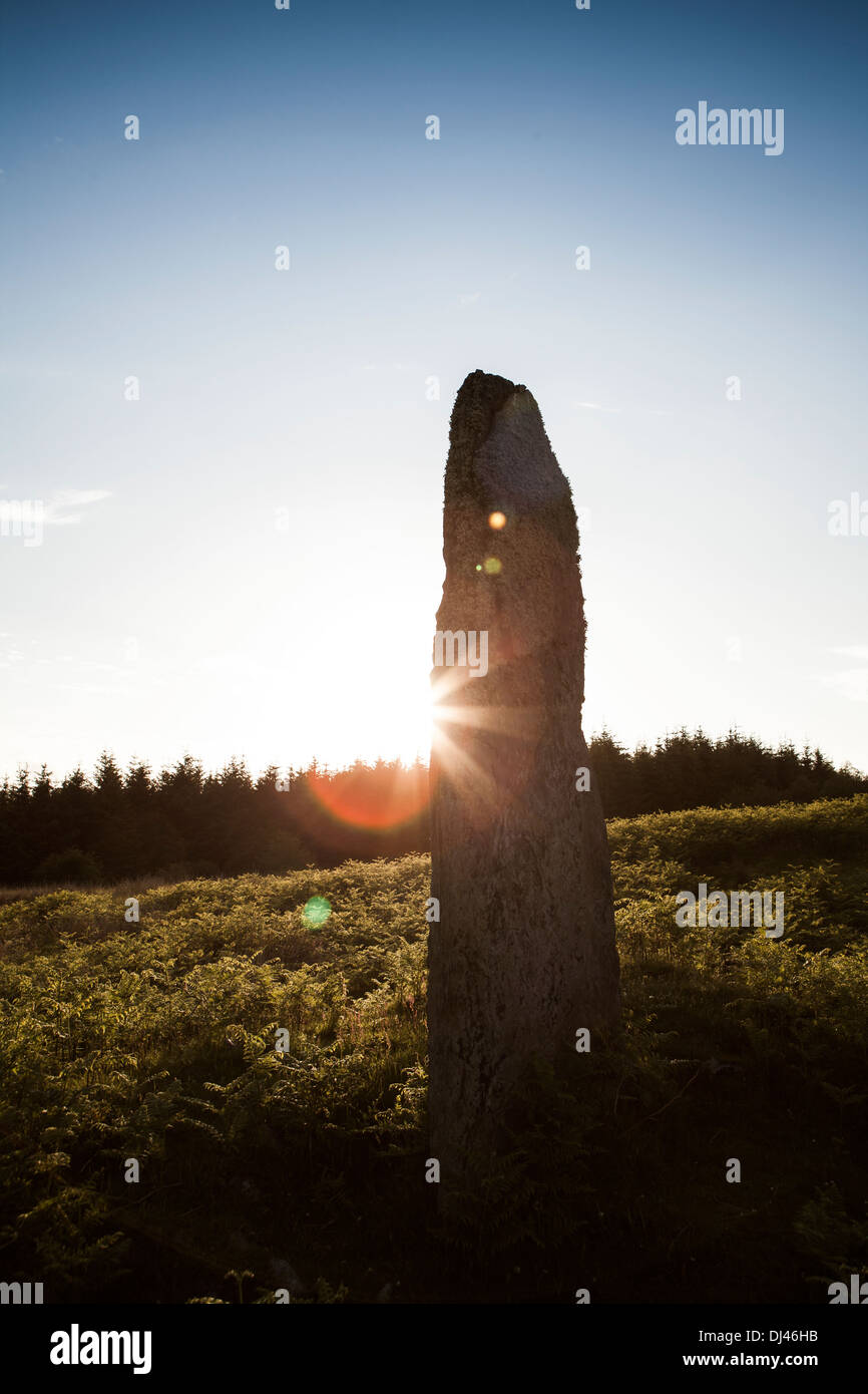 Eine alte Menhir mit durchdringenden Strahlen der Sonne. Stockfoto