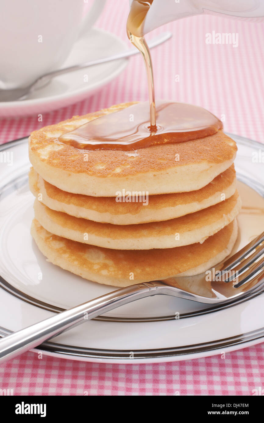 Ahornsirup auf Buttermilch Pfannkuchen gießen Stockfoto