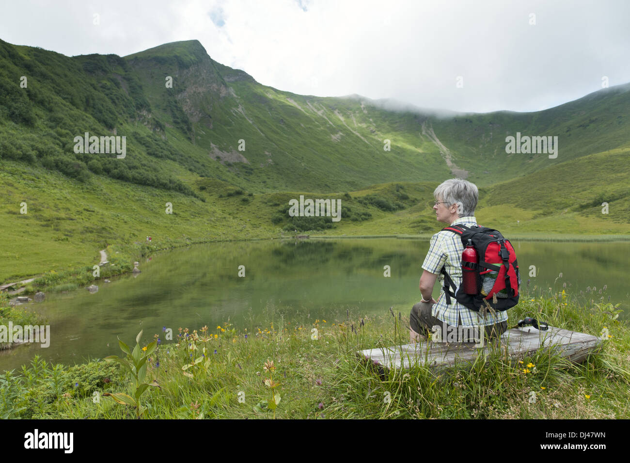 Frau sitzt auf einer Bank am Schlappoldsee Stockfoto