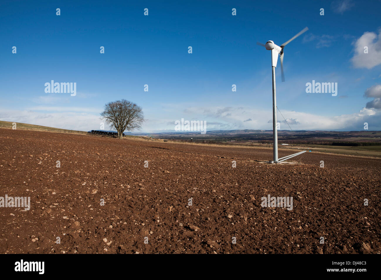 Windturbine gegen ein strahlend blauer Himmel auf einem Bauernhof. Stockfoto
