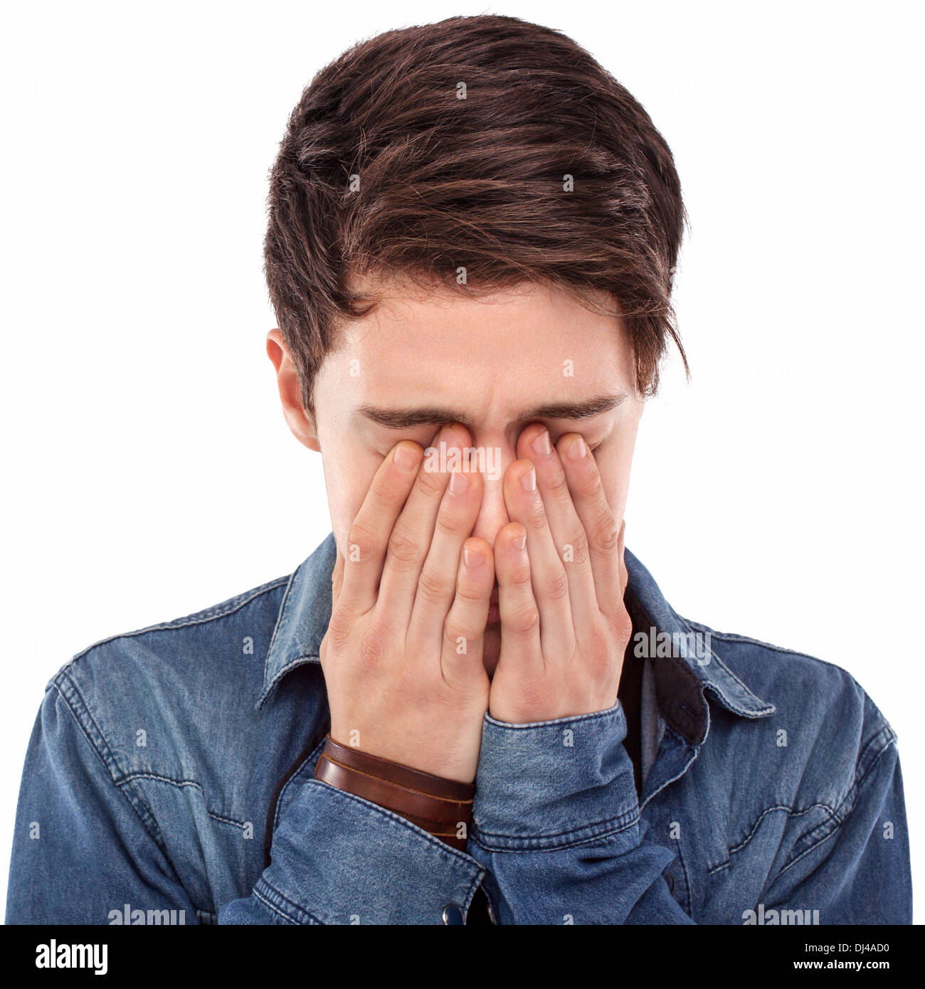 Junger Mann versteckt sein Gesicht mit den Händen Stockfoto