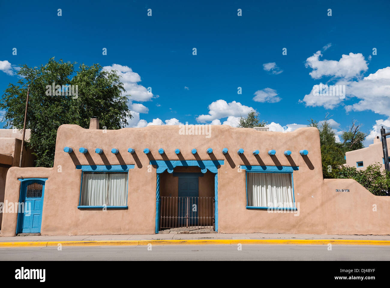 Adobe Gebäude im traditionellen Farbe und Stil in Santa Fe, New Mexico, USA mit türkisfarbenen Vigas und Rim gegen blauen Himmel. Stockfoto