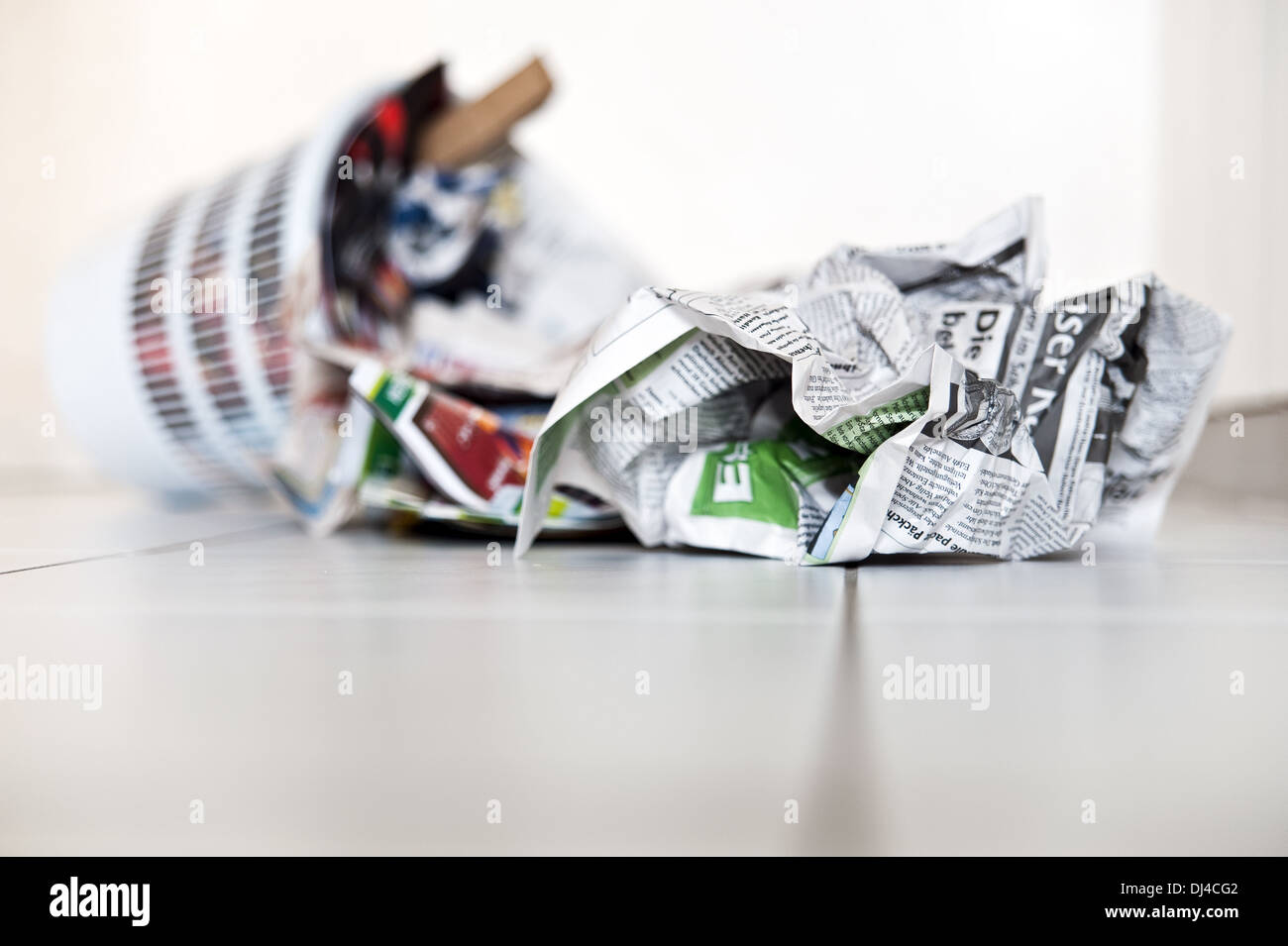 umgestürzter Müll mit Zeitungen Stockfoto