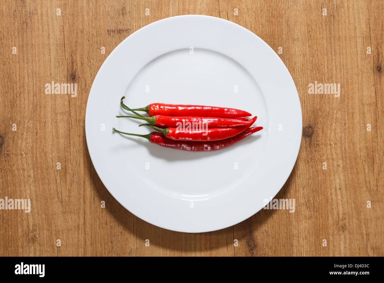 Rote Chilis auf einem weißen Teller Stockfoto