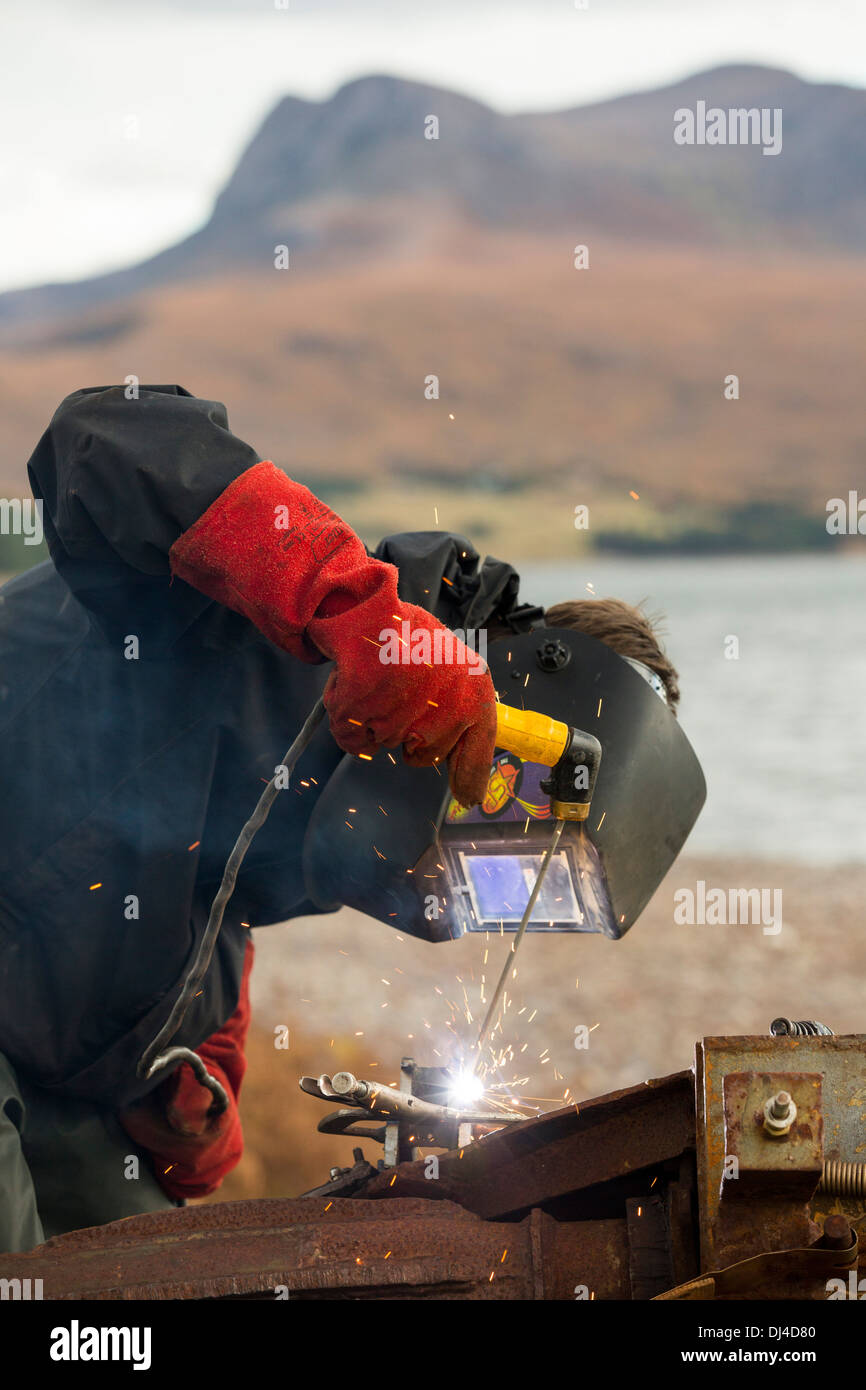 Hugh Piggott Wartungsarbeiten über seine hausgemachten Windkraftanlagen in Scoraig, in NW Schottland, eine Fernbedienung aus Netz, Community, UK Stockfoto