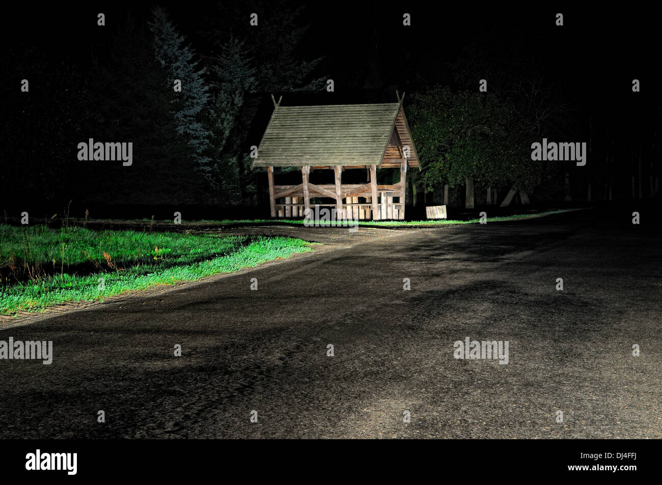 Bushaltestelle in Autoscheinwerfern Stockfoto