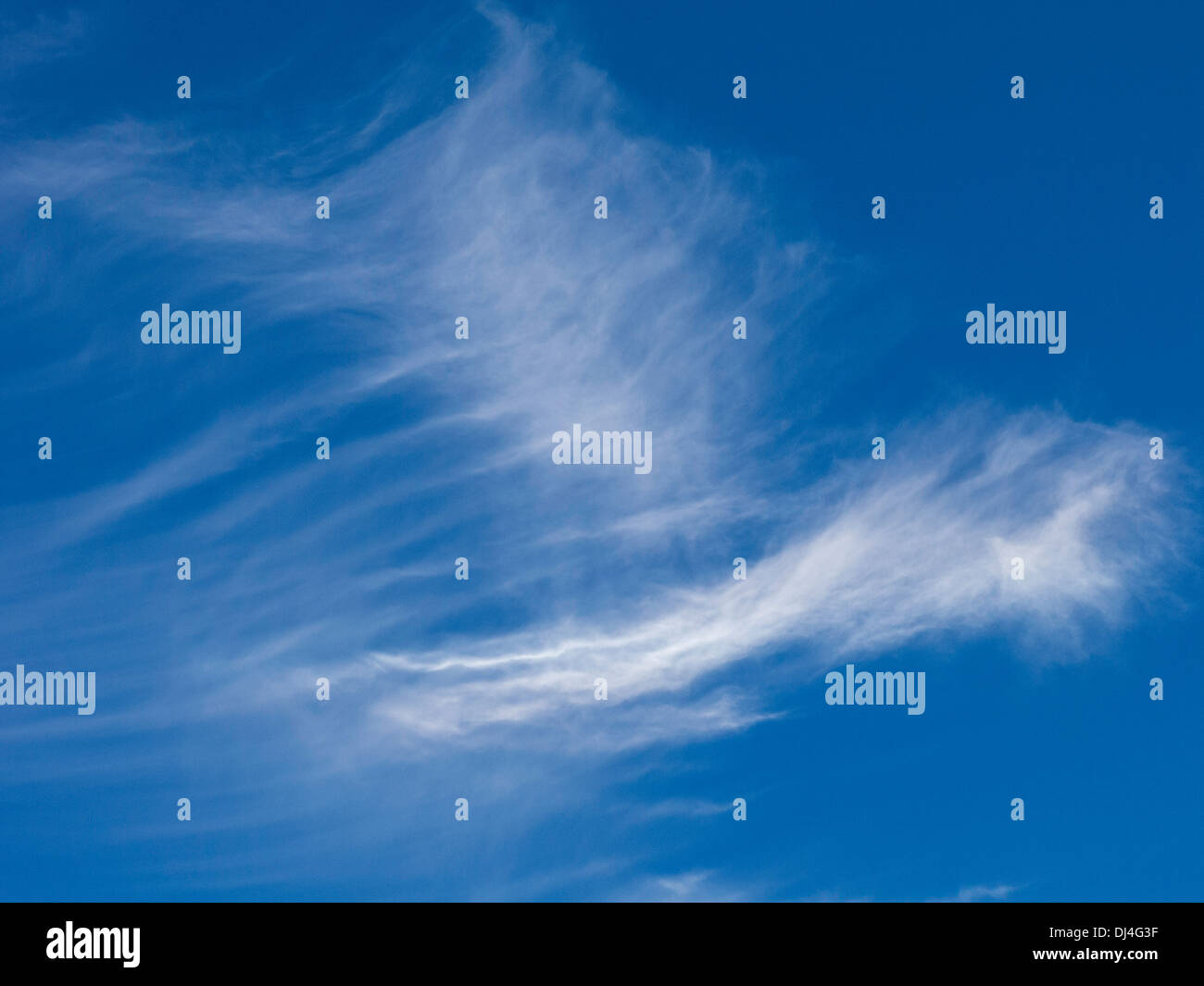 Blauer Himmel und Wolkenfetzen Stockfoto