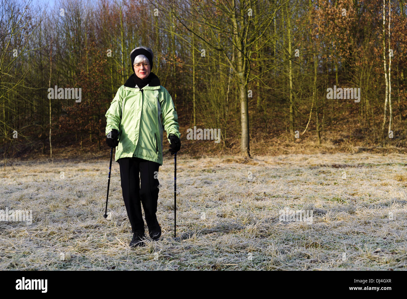 Frau-Nordic-walking-auf einer Wiese Stockfoto