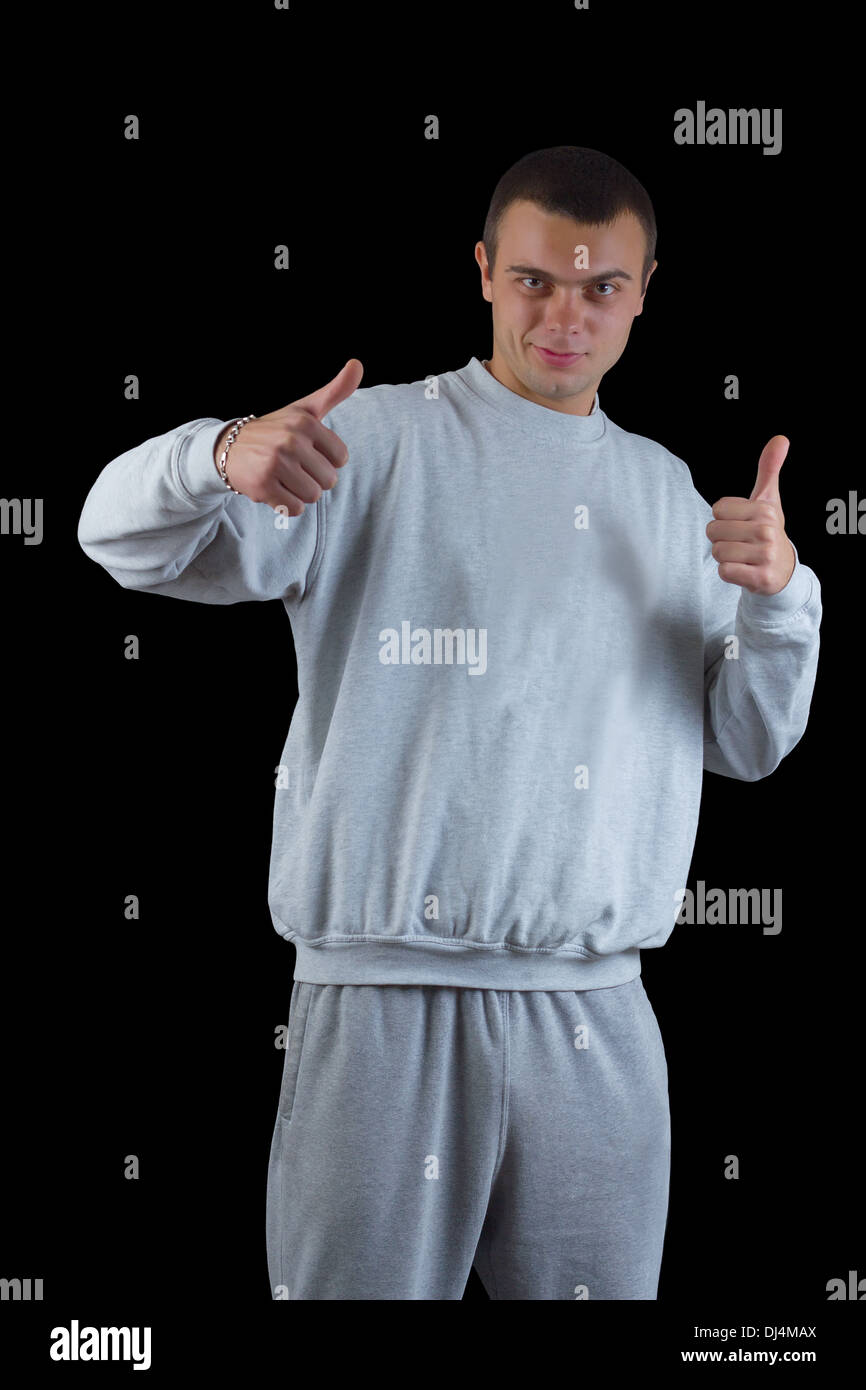 junger Kerl in einem Trainingsanzug auf schwarzem Hintergrund Stockfoto