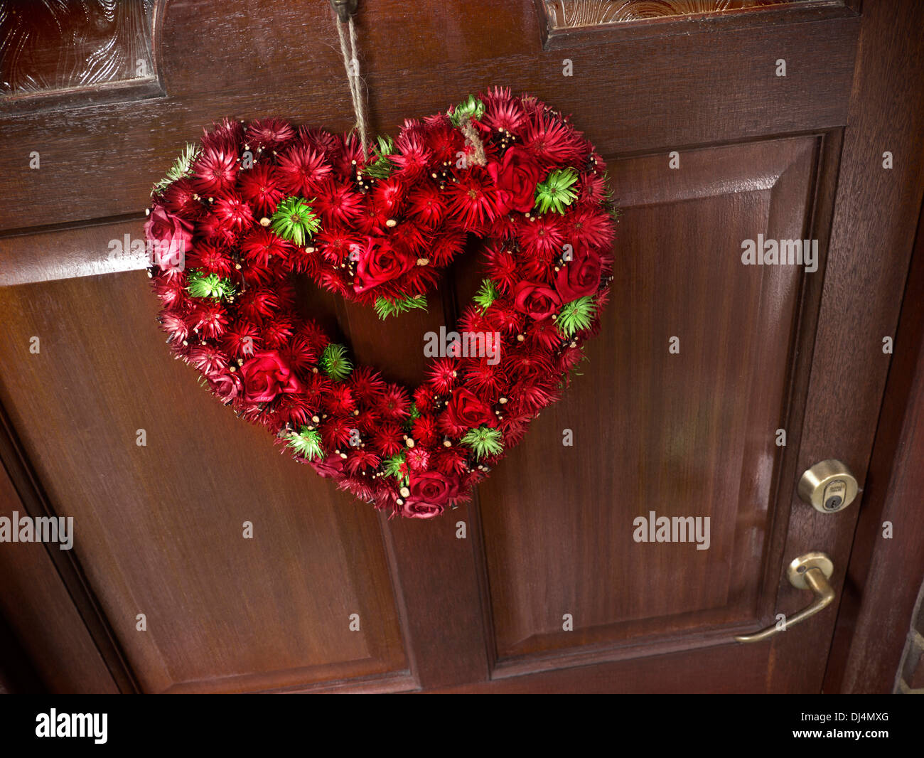 Christmas Herz Blumenemblem an Eingangstür typischen Hauses hängen Stockfoto
