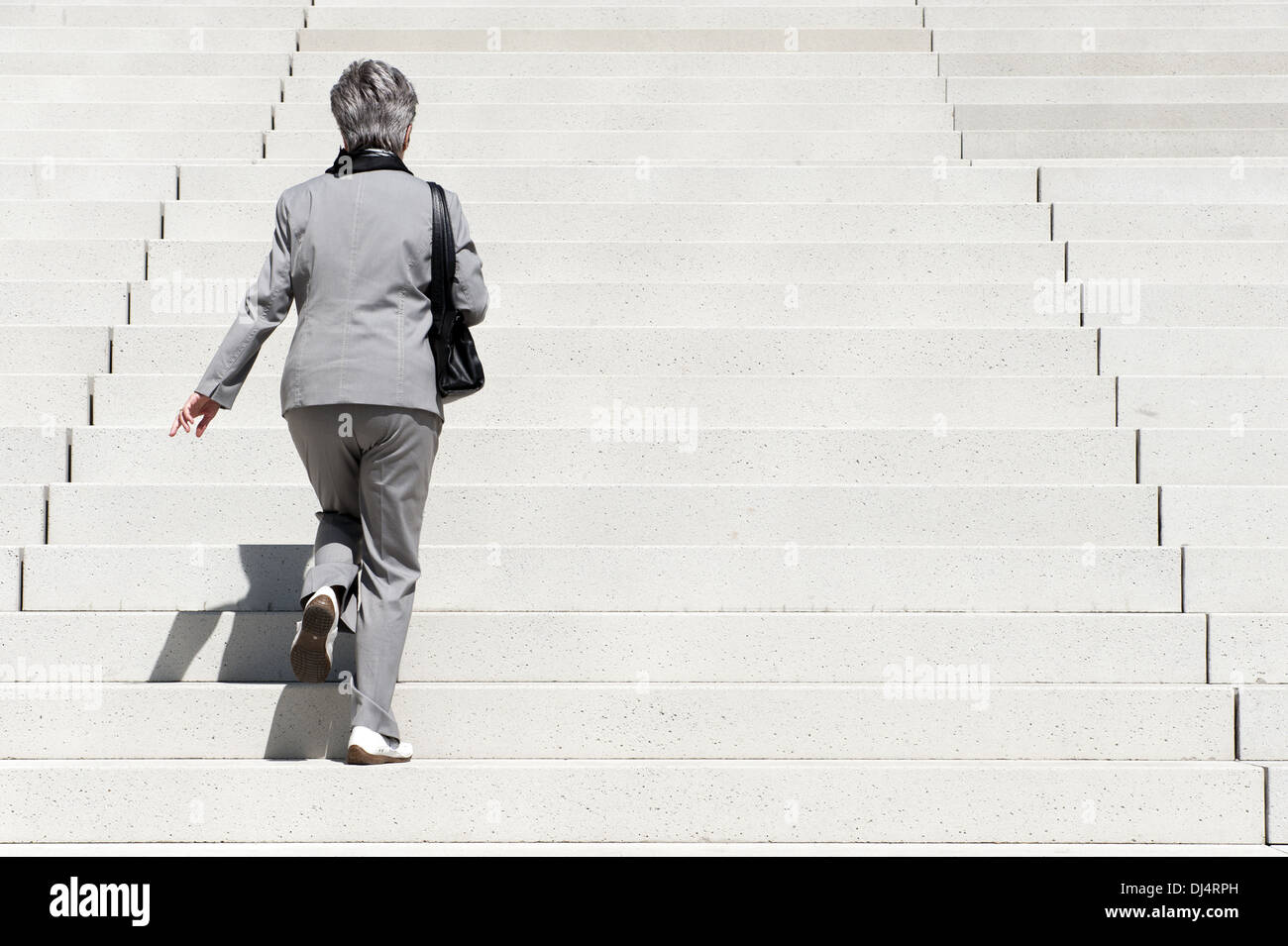 Frau steht auf einer großen Treppe Stockfoto