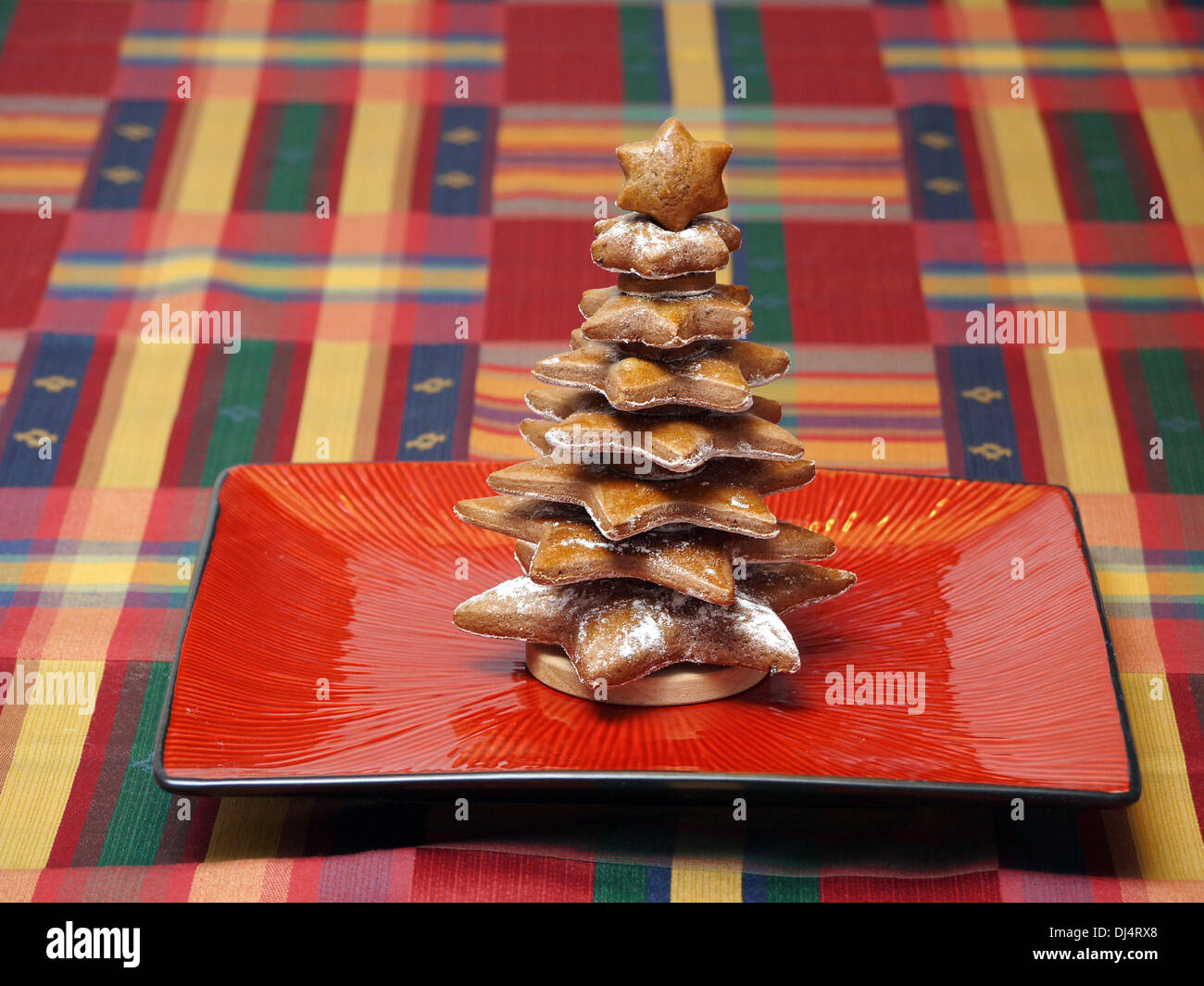 Lebkuchen-Kuchen-Weihnachtsbaum auf rotem Teller Stockfoto