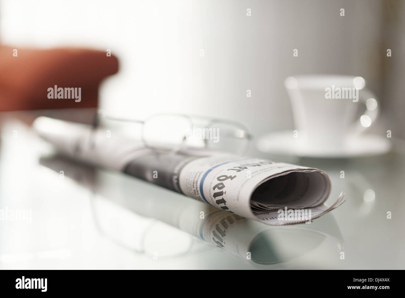 rollte Zeitung sitzt auf einem Couchtisch Stockfoto