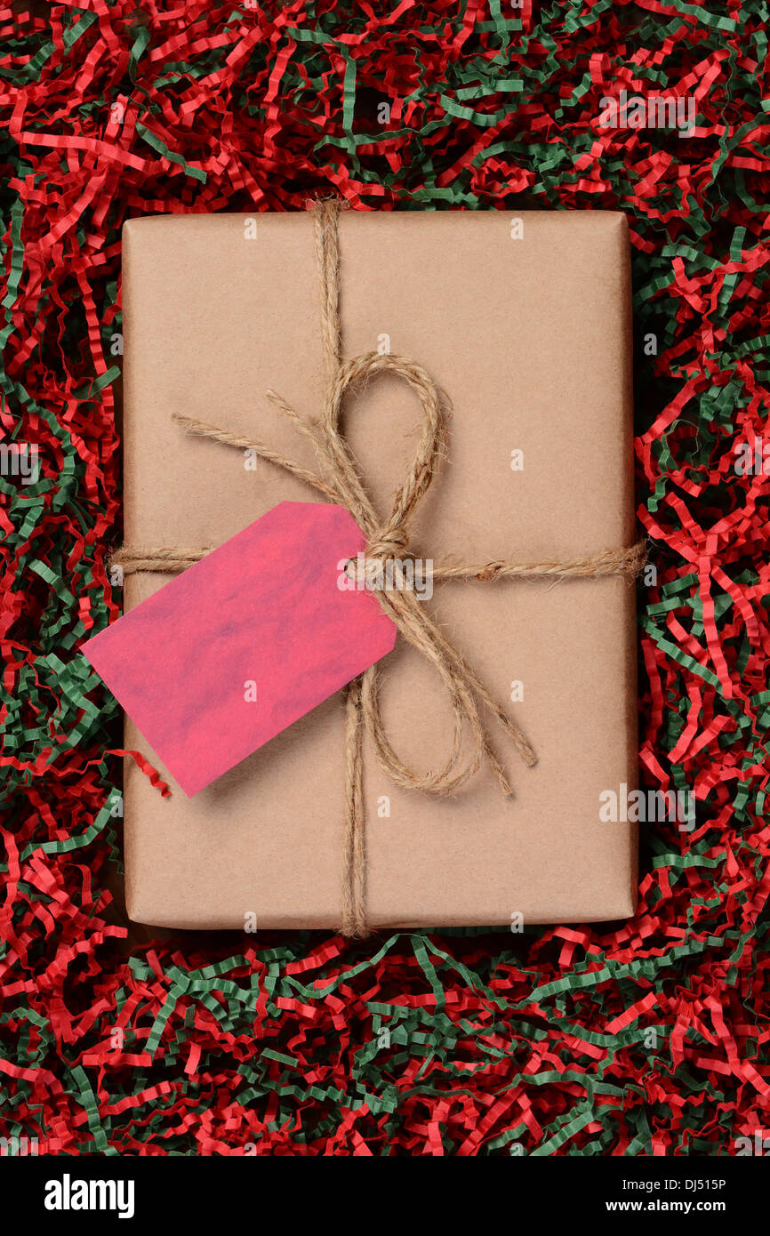 Draufsicht auf ein einziges Weihnachtsgeschenk mit Eco freundliche Handwerk Papier eingewickelt und mit Bindfaden gebunden. Stockfoto