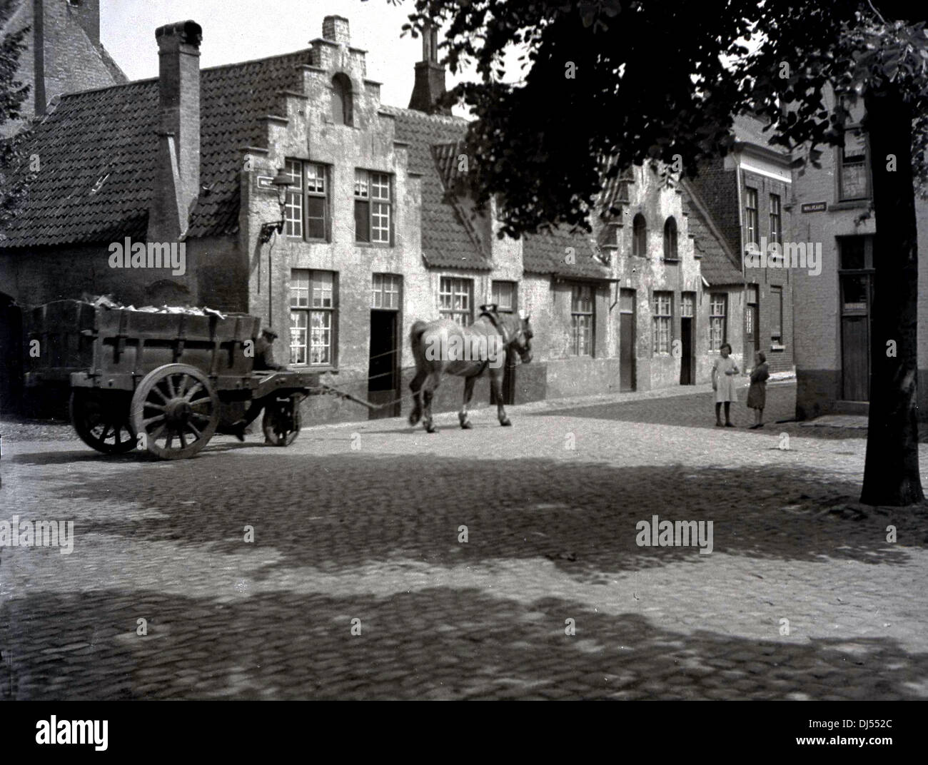 Historisches Bild von der 1930er Jahre. Pferd und Wagen fahren auf einer gepflasterten Straße, Lüttich, Belgien. Stockfoto