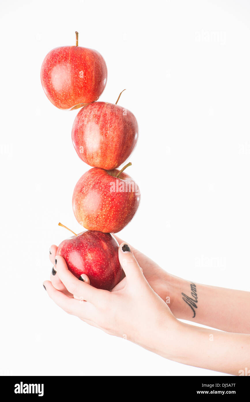 Frau Ausgleich vier rote Äpfel Stockfoto