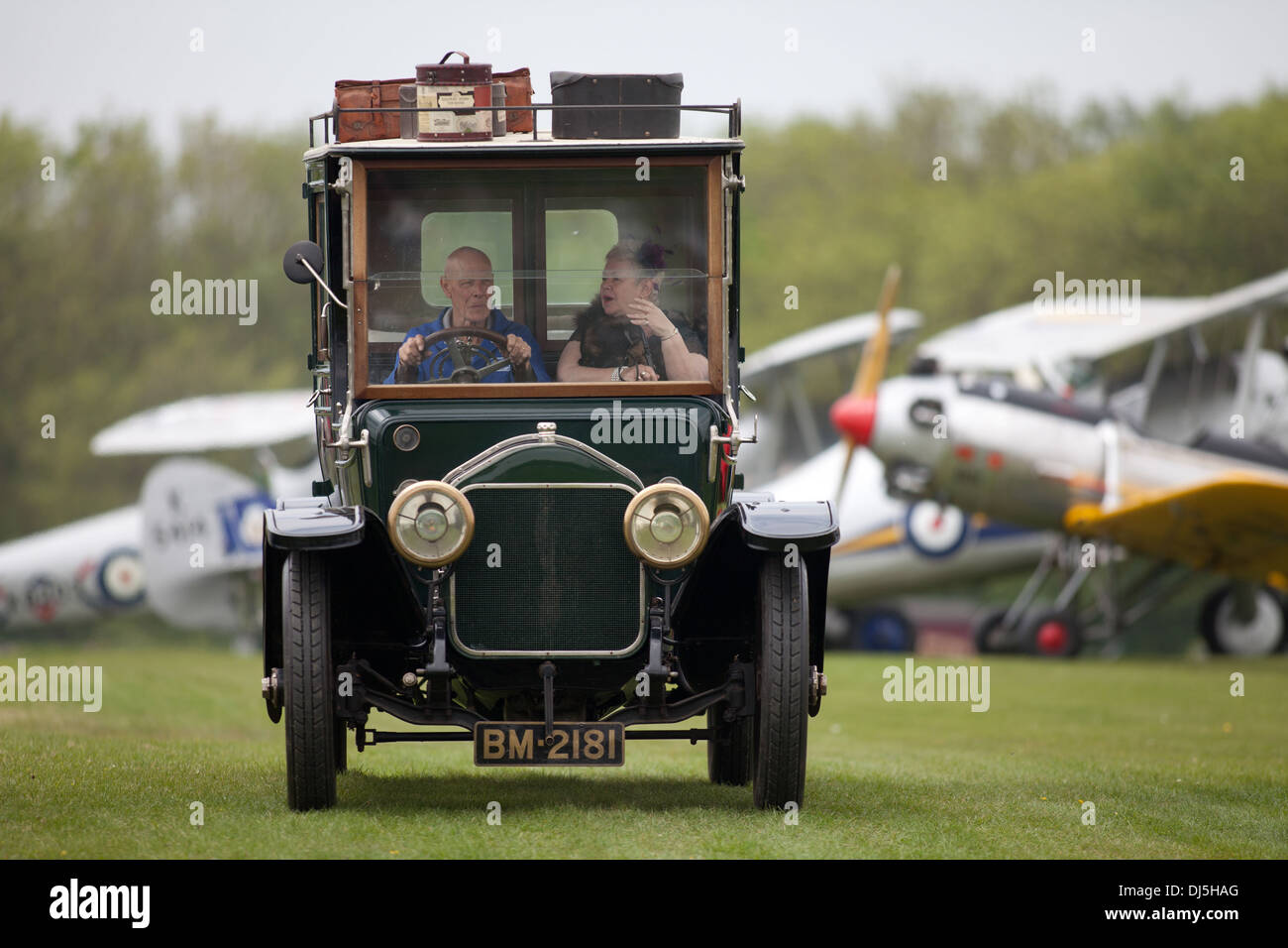 Oldtimer fährt entlang einer Linie von Flugzeugen bei einer Flugschau Shuttleworth Collection Airfield Old Warden, Bedfordshire, UK Stockfoto