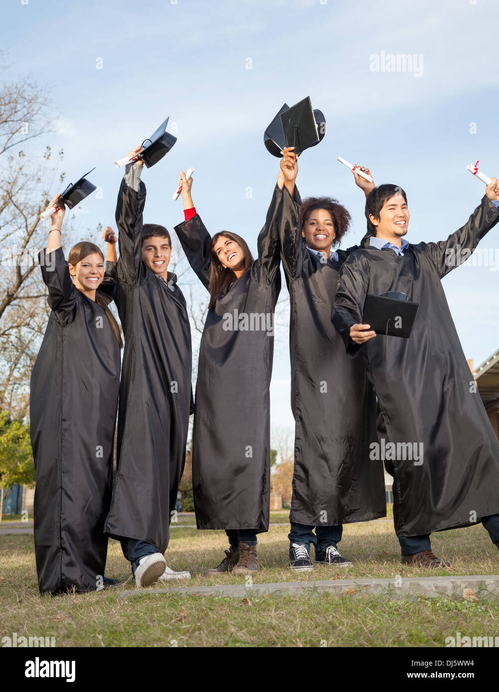 Studenten mit Diplomen feiert Erfolg am Abschlusstag am Stockfoto