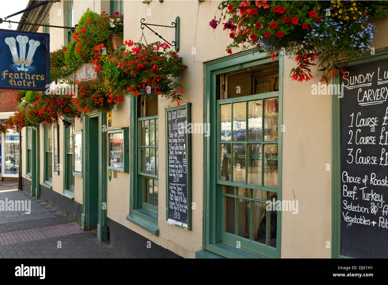 Hängeaufbewahrung Blumen außerhalb Feathers Hotel, Marktplatz, Holt, Norfolk, England, Vereinigtes Königreich, UK, Europa Stockfoto