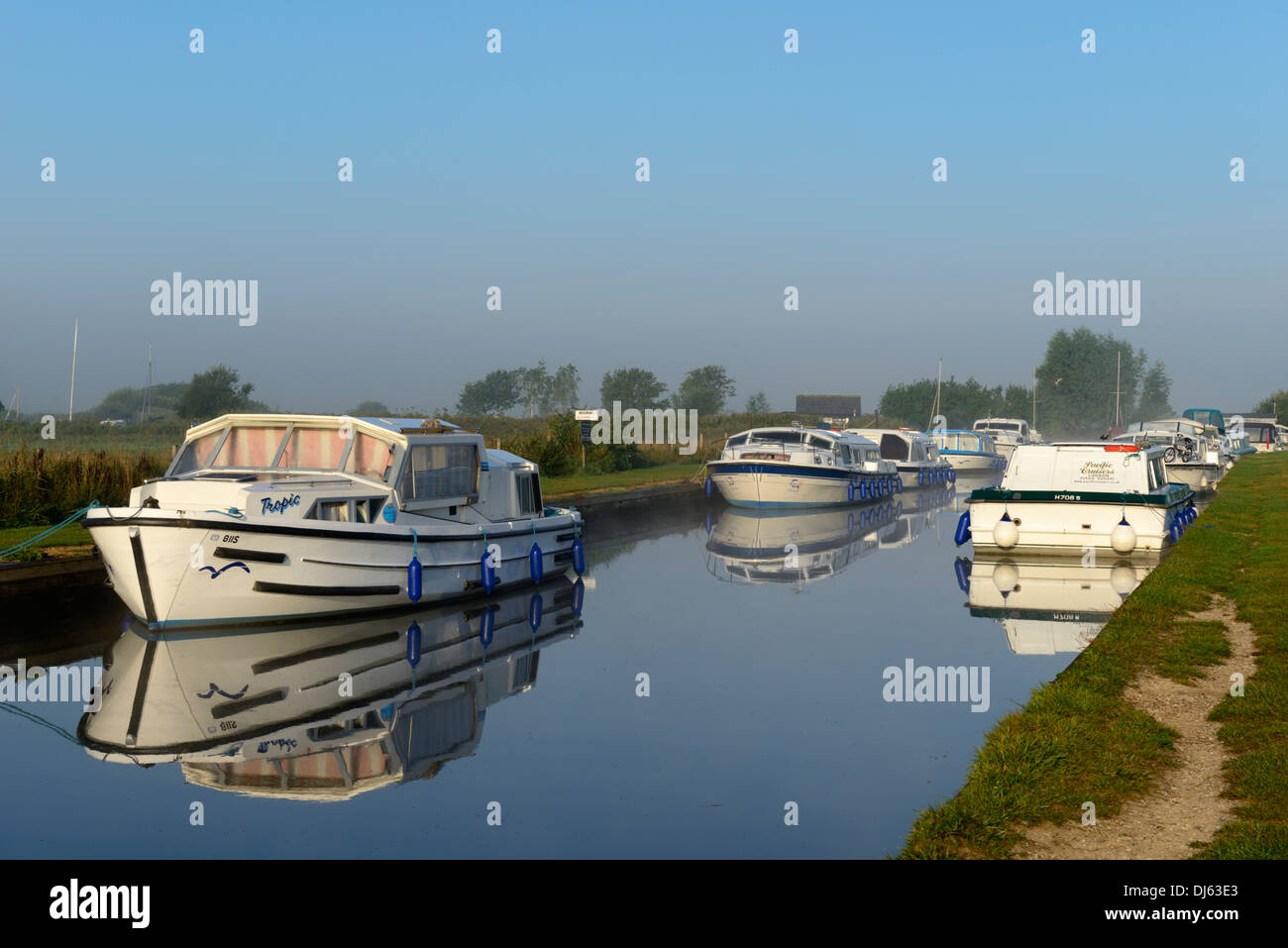 Sportboote im frühen Morgennebel und Sonnenschein auf dem Fluß Thurne, Thurne, Norfolk, England, United Kingdom, UK, Europa Stockfoto