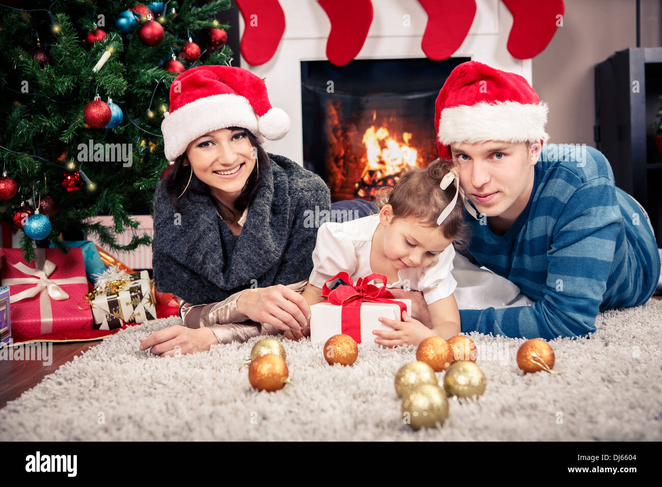 junge Familie vor Weihnachtsbaum Stockfoto