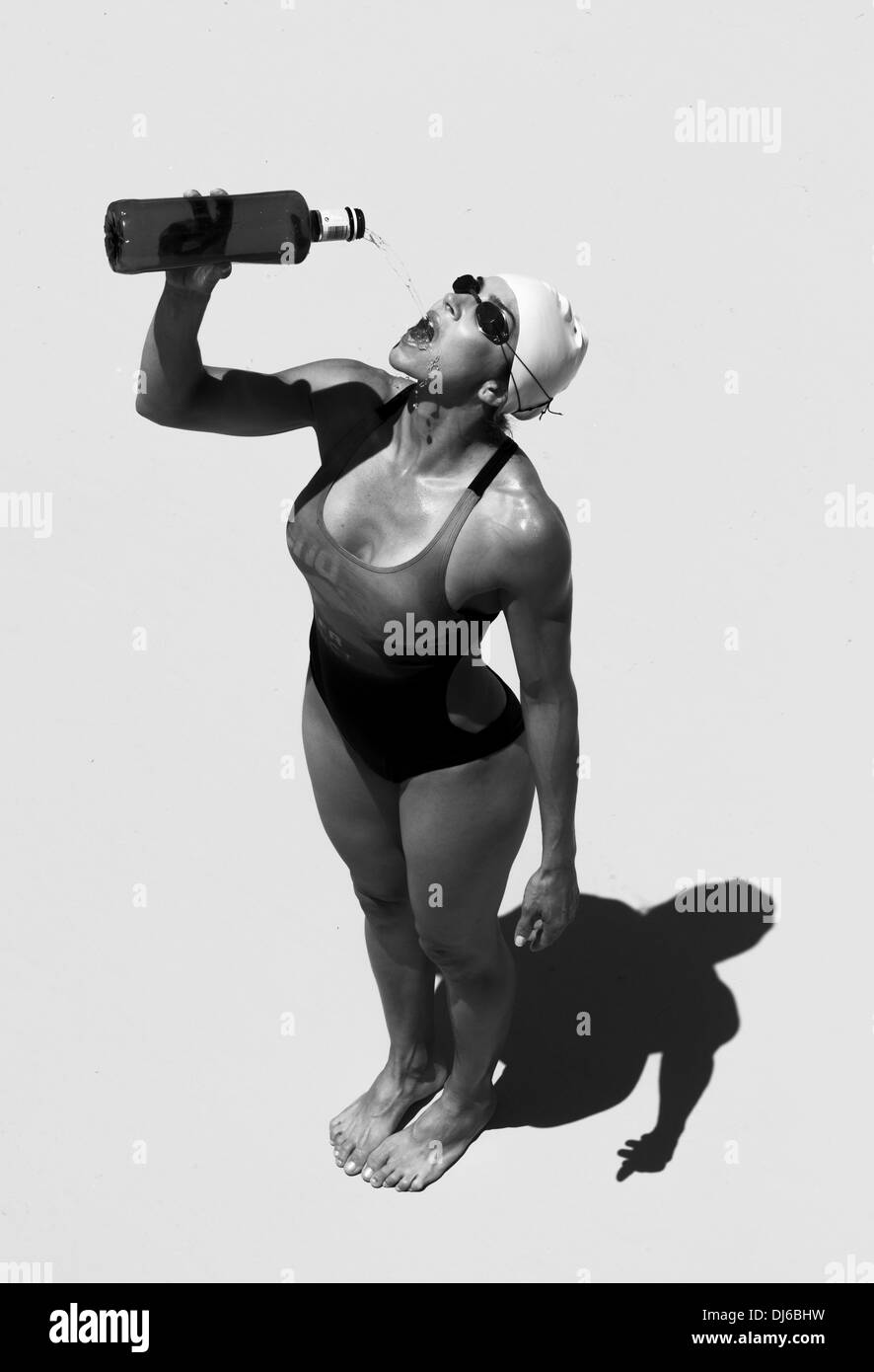 Eine weibliche Schwimmer Getränke aus einer Wasserflasche; Tarifa, Cádiz, Andalusien, Spanien Stockfoto