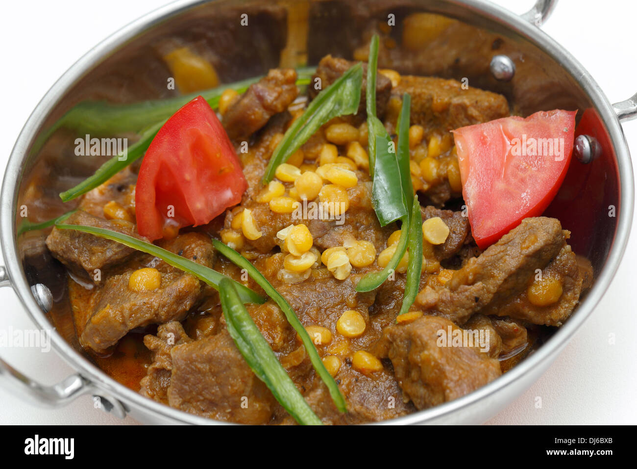 Lahore (Pakistan) Lamm und Chana Dhal (Split Pea) Curry, garniert mit Tomaten und Chilischoten, und mit Reis serviert. Stockfoto