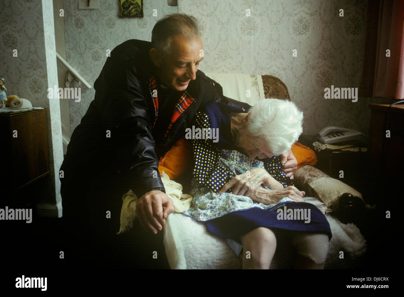 Vater Alex Reid. Katholische Priester mit Sitz in West Belfast, eine ältere Dame in seiner Pfarrei zu trösten. Stockfoto