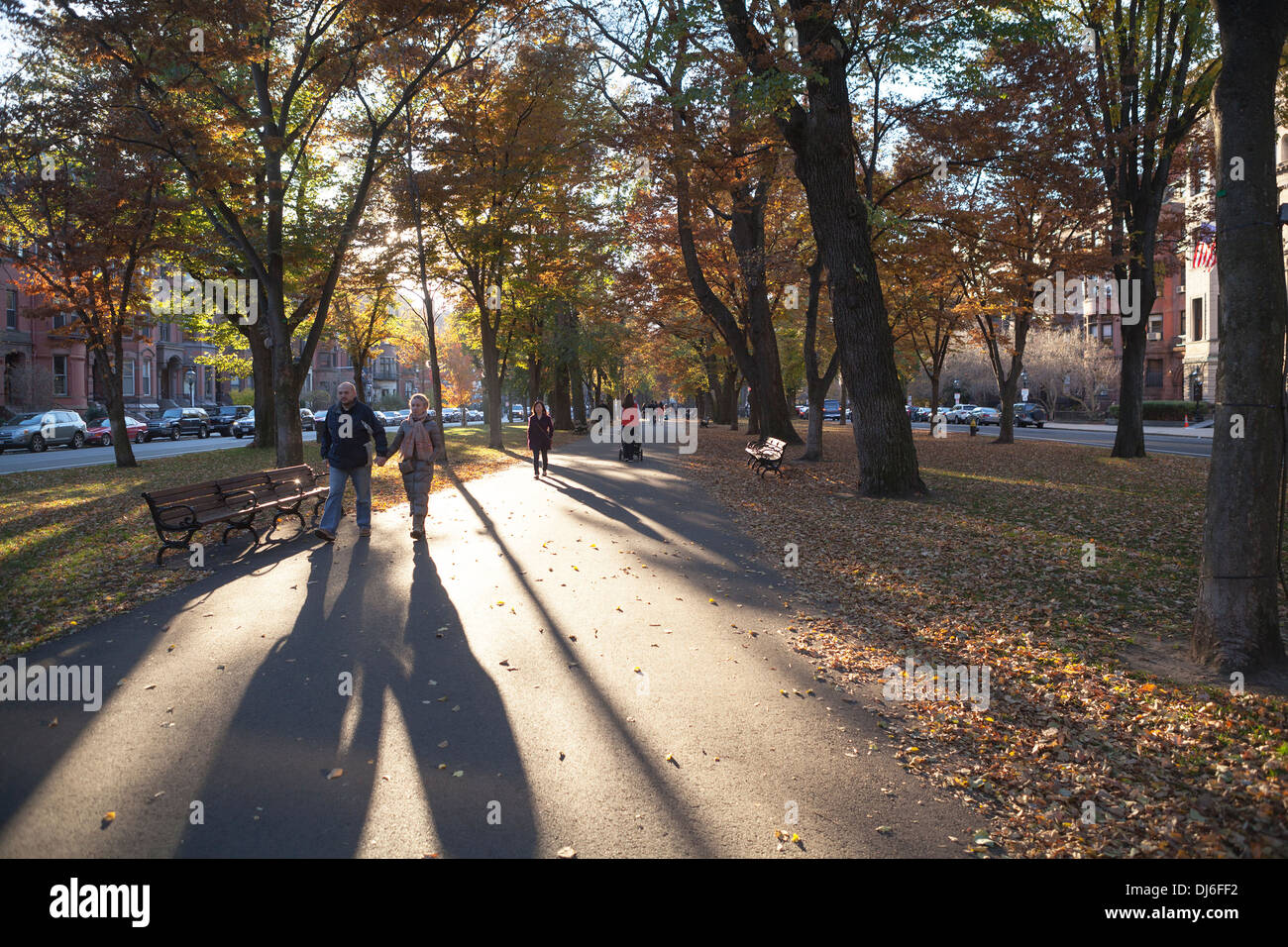 Menschen werfen lange Schatten bei einem Spaziergang durch einen Park in Boston. Stockfoto