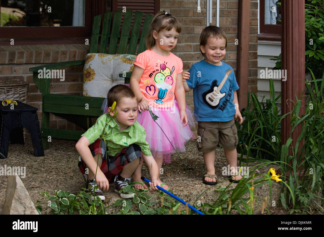 Fünf Jahre alten Bruder, drei Jahre alte Schwester und zwei Jahre alten Cousin spielen auf der Veranda des s-Bahn-Home Stockfoto