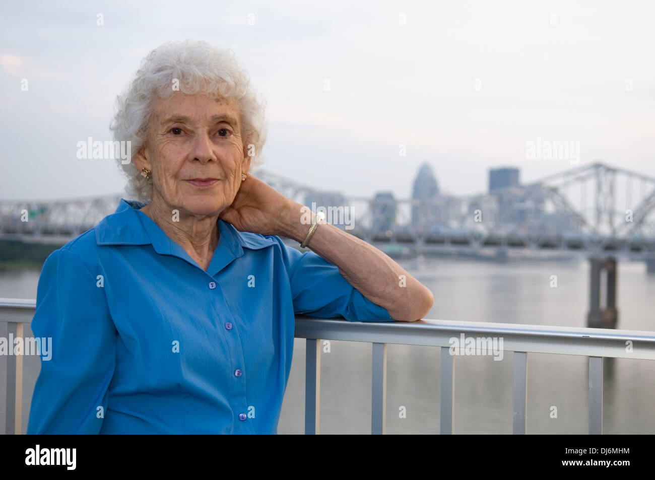 Ältere Frau posiert für Fotos auf der großen vier Fußgängerbrücke mit Louisville Kentucky im Hintergrund Stockfoto