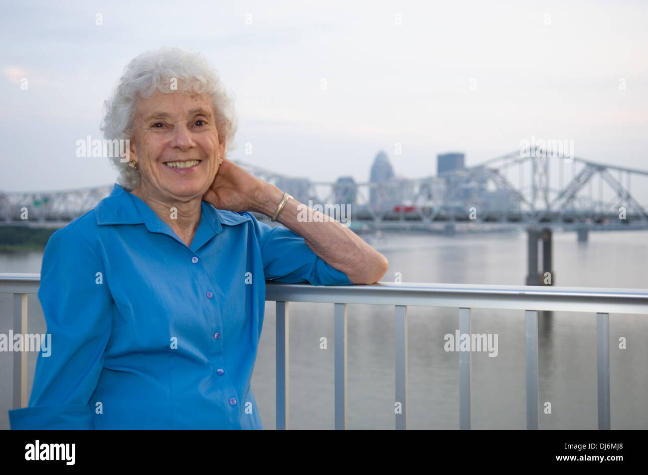 Ältere Frau posiert für Fotos auf der großen vier Fußgängerbrücke mit Louisville Kentucky im Hintergrund Stockfoto