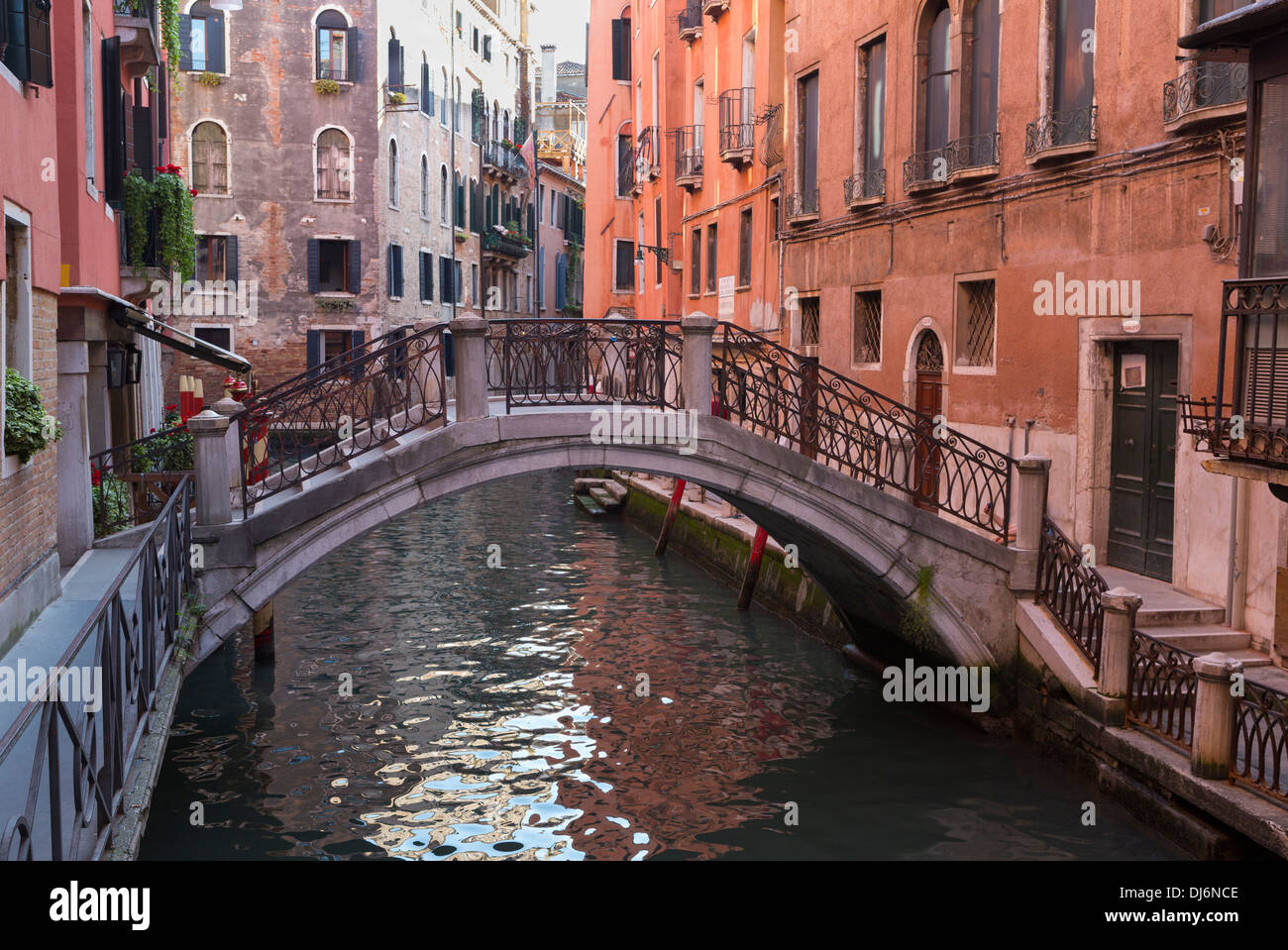 Schöne kleine Brücke über einen kleinen Kanal, gesäumt von bunten Gebäuden in Venedig, Italien Stockfoto