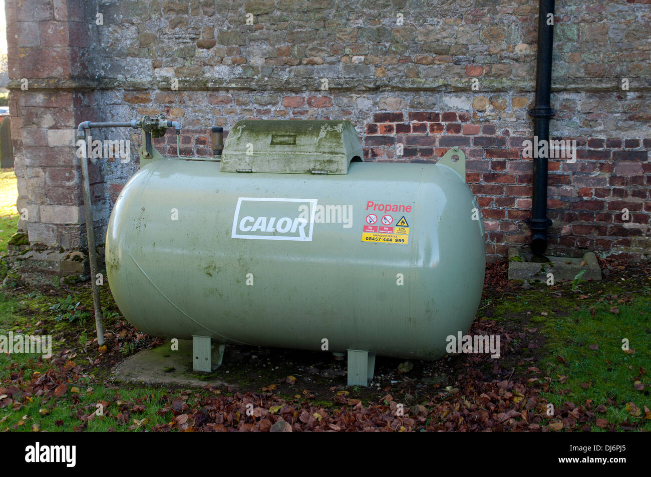 Propan-Gas-Tank, St.-Nikolaus-Kirchhof, Mowsley, Leicestershire, England, UK Stockfoto