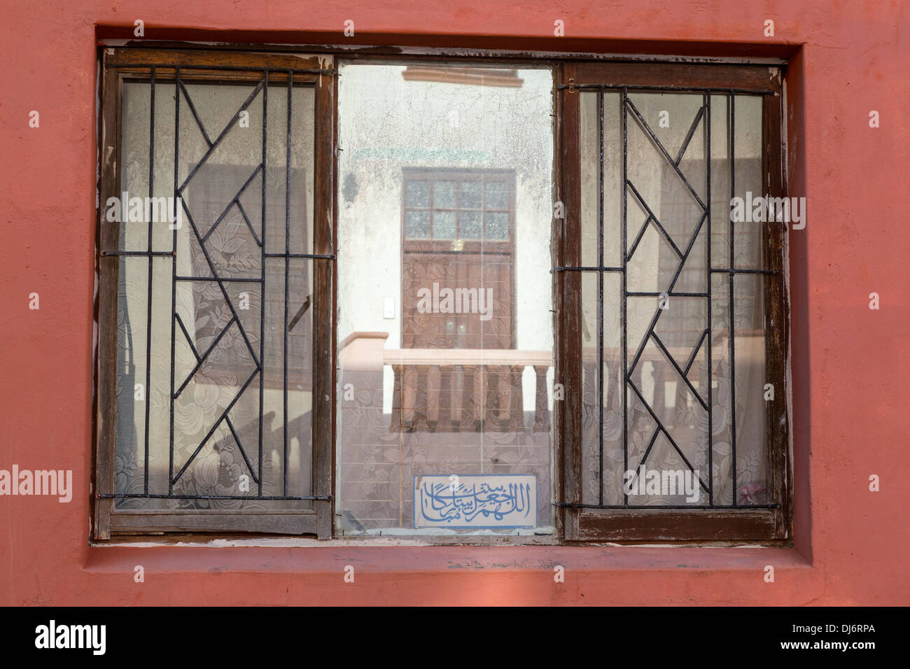 Südafrika, Cape Town, Bo-Kaap. Spiegelbild im Fenster, arabische Inschrift am Boden. Stockfoto