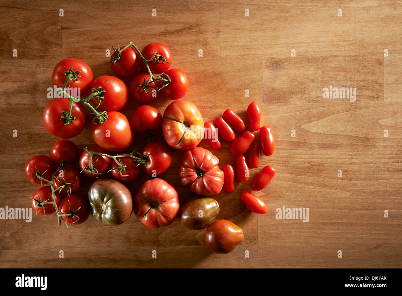Tomaten auf einem Brett und Bauern-Markt. Verschiedene Sorten und am Rebstock. Ideal für Salate und Konserven. Kirsche Stockfoto