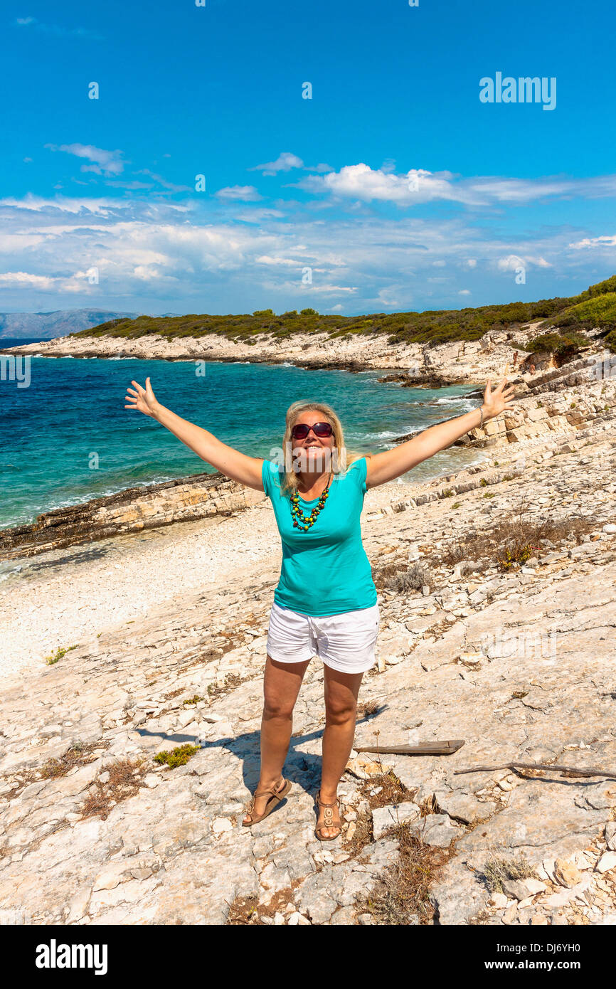 Glückliche Frau am Strand von Veli Bili Bok, Insel Proizd, Kroatien Stockfoto