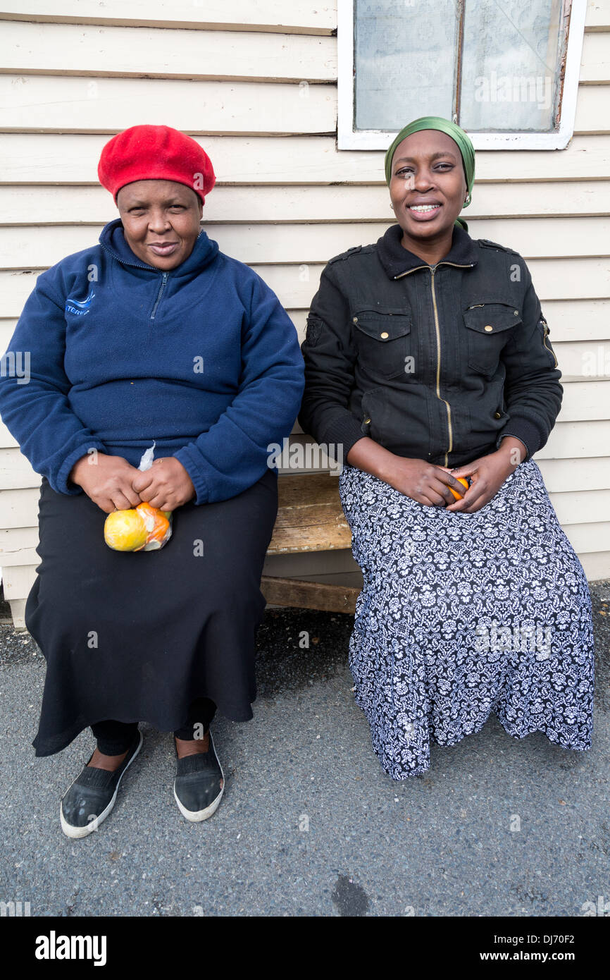 Südafrika, Cape Town, Guguletu Township. Zwei Frauen sitzen auf einer Bank. Stockfoto