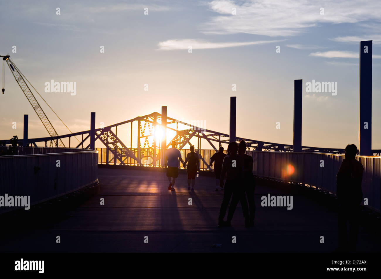 Menschen, die Silhouette bei Sonnenuntergang auf der Ranp, die großen vier Fußgängerbrücke mit der Kennedy-Brücke im Hintergrund Stockfoto
