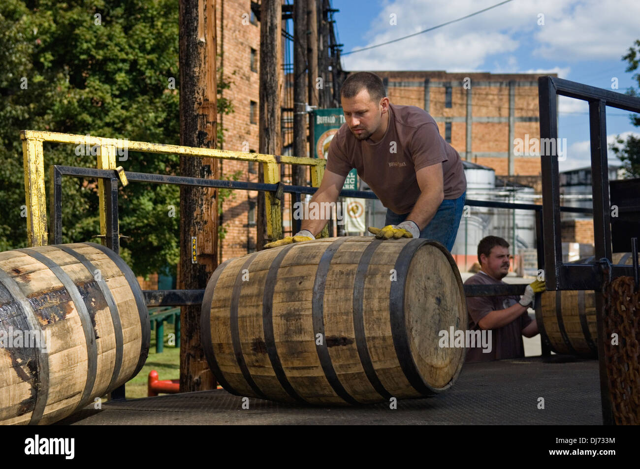 Worker bei Buffalo Trace Distillery Rollen Barrel von Bourbon von der Rückseite eines LKW in Frankfort, Kentucky Stockfoto