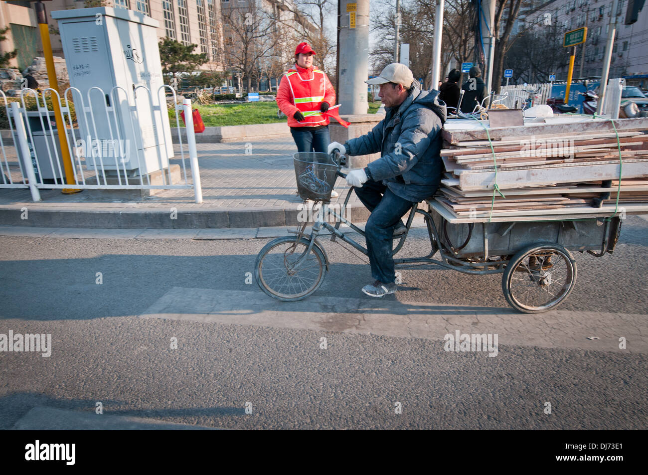 Mann mit Planken auf dem Fahrrad Wagen auf Straße in Peking, China Stockfoto