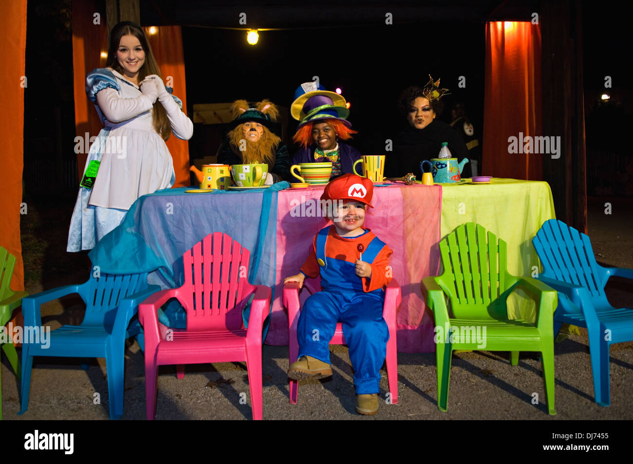 Kleinkind verkleidet als Mario für Halloween mit Charactors aus Alice im Wunderland auf der Louisville Zoo Halloweenparty Stockfoto