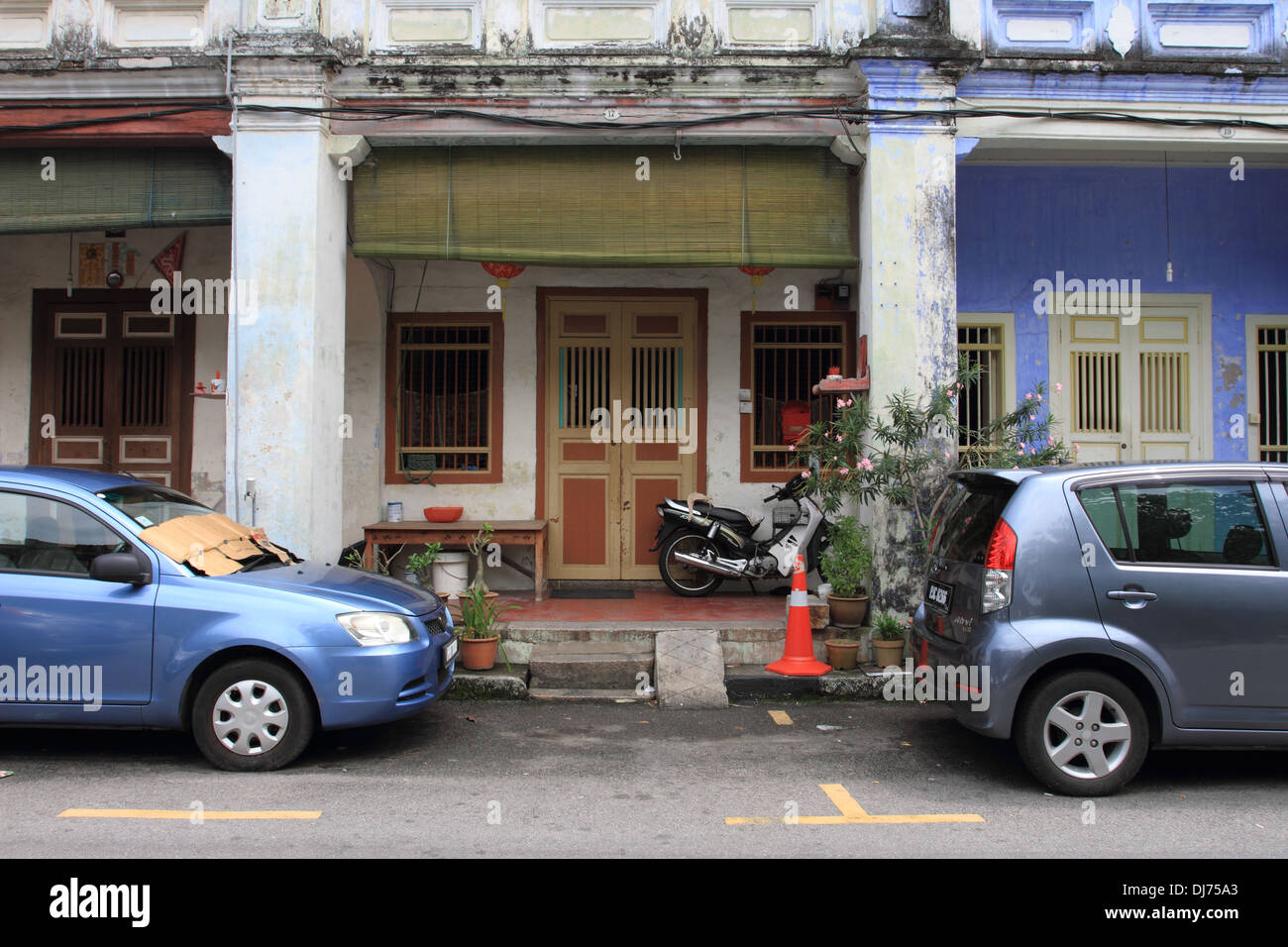Traditionelles chinesisches Haus mit Autos und Motorradpark vor dem Hotel, George Town, Penang Island, Malaysia Stockfoto
