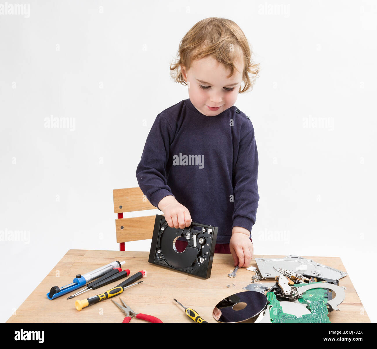 Vorschüler mit Computer-Teile auf Schreibtisch aus Holz. Studio in hellen grauen Hintergrund gedreht Stockfoto