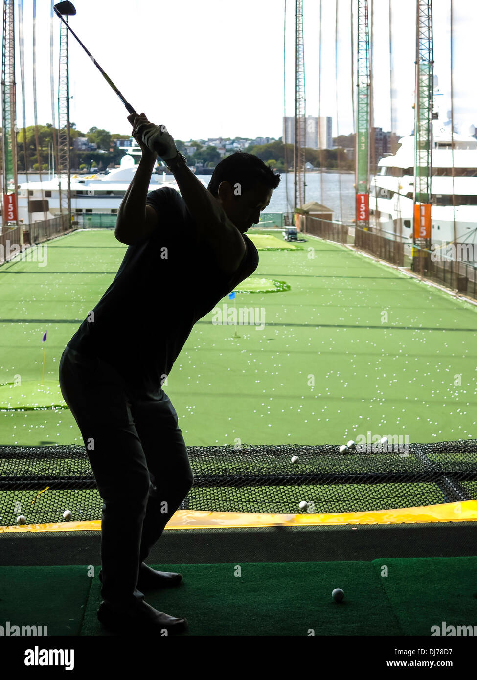 Golfer üben Schwung, der Golf Club at Chelsea Piers Sport & Entertainment-Komplex, NYC Stockfoto